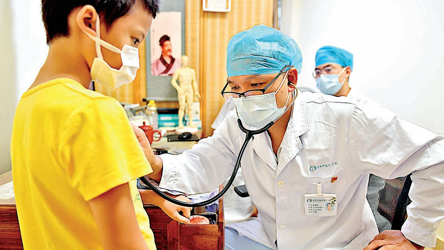 宝安中医院(集团)儿科学科带头人,主任中医师林国彬正在为小患者听诊.